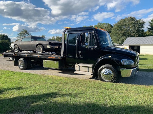 Roscoe's tow truck hauling a junk car in the Richmond, Virginia area